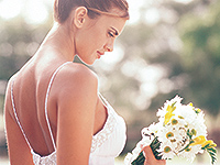 Bride with flowers showered in bright light